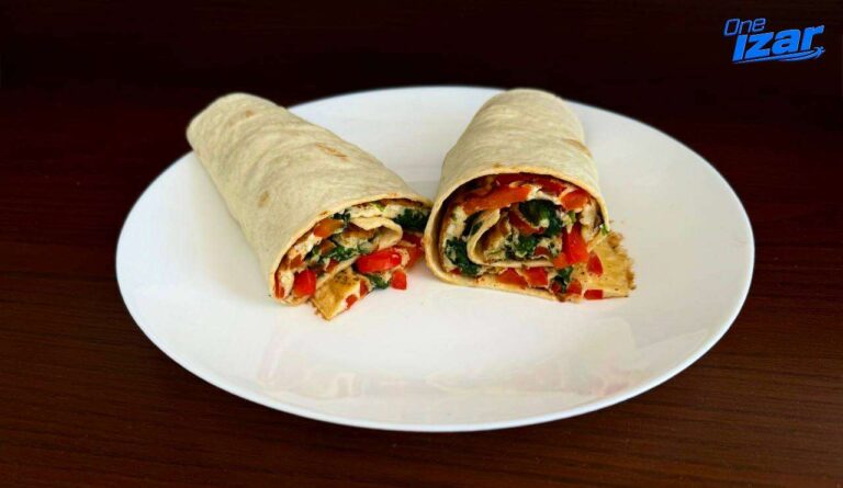High-protein egg and veggie wrap sliced in half on a plate
