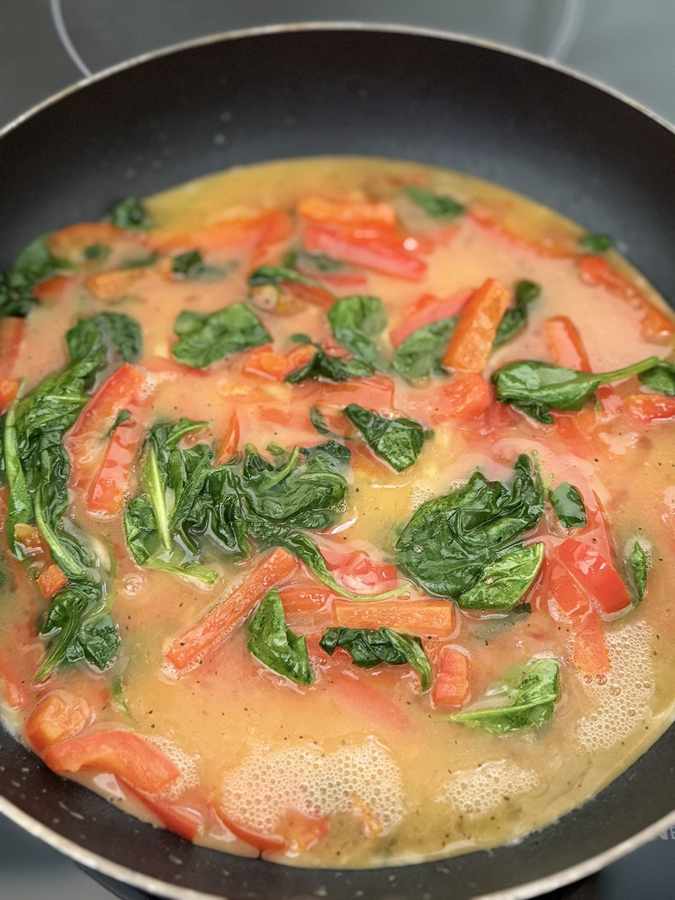 Egg and vegetable mixture scrambling in a pan