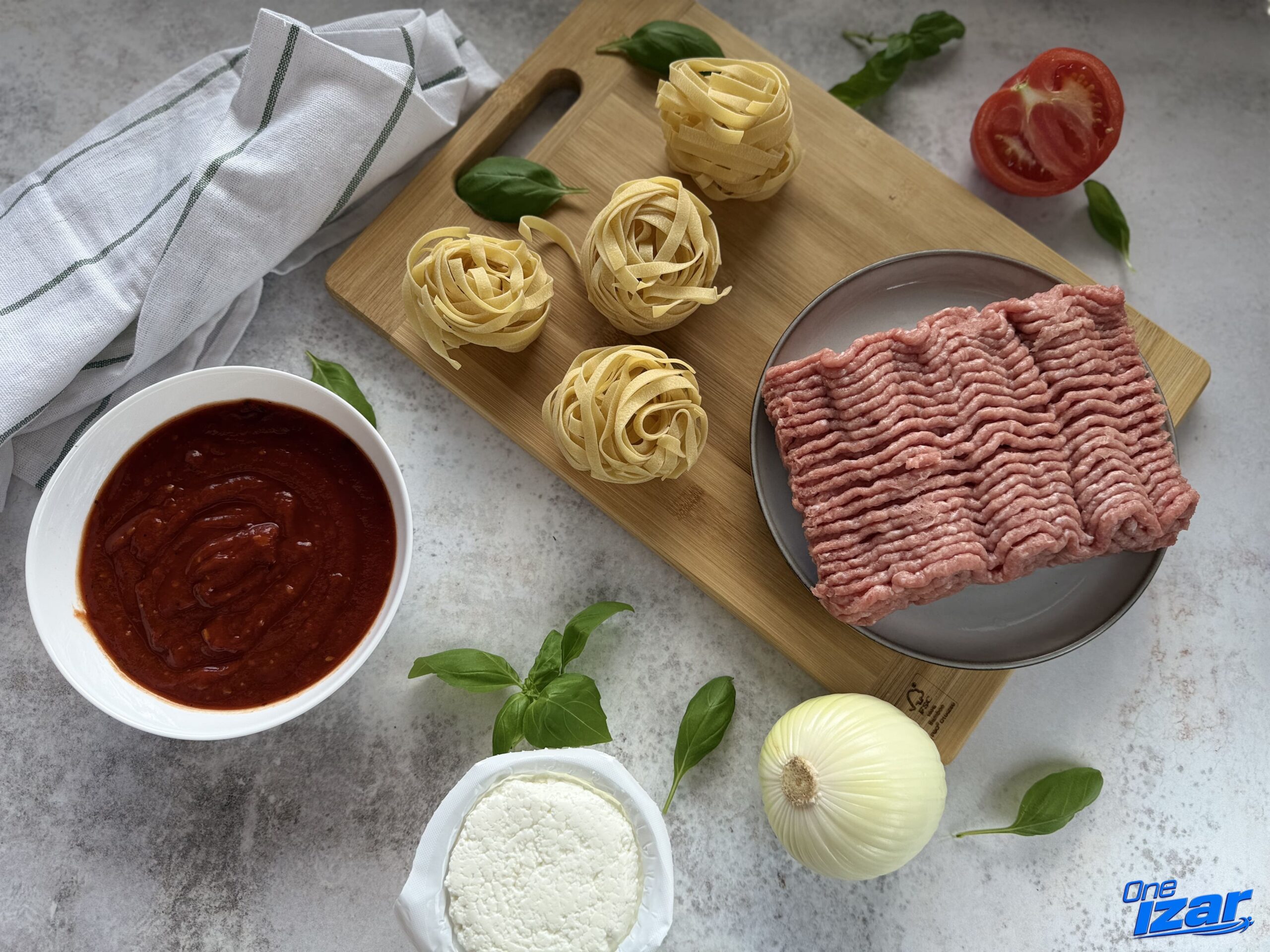Ingredients for high-protein turkey bolognese pasta: tagliatelle, turkey mince, tomato sauce, cottage cheese, onion and fresh basil